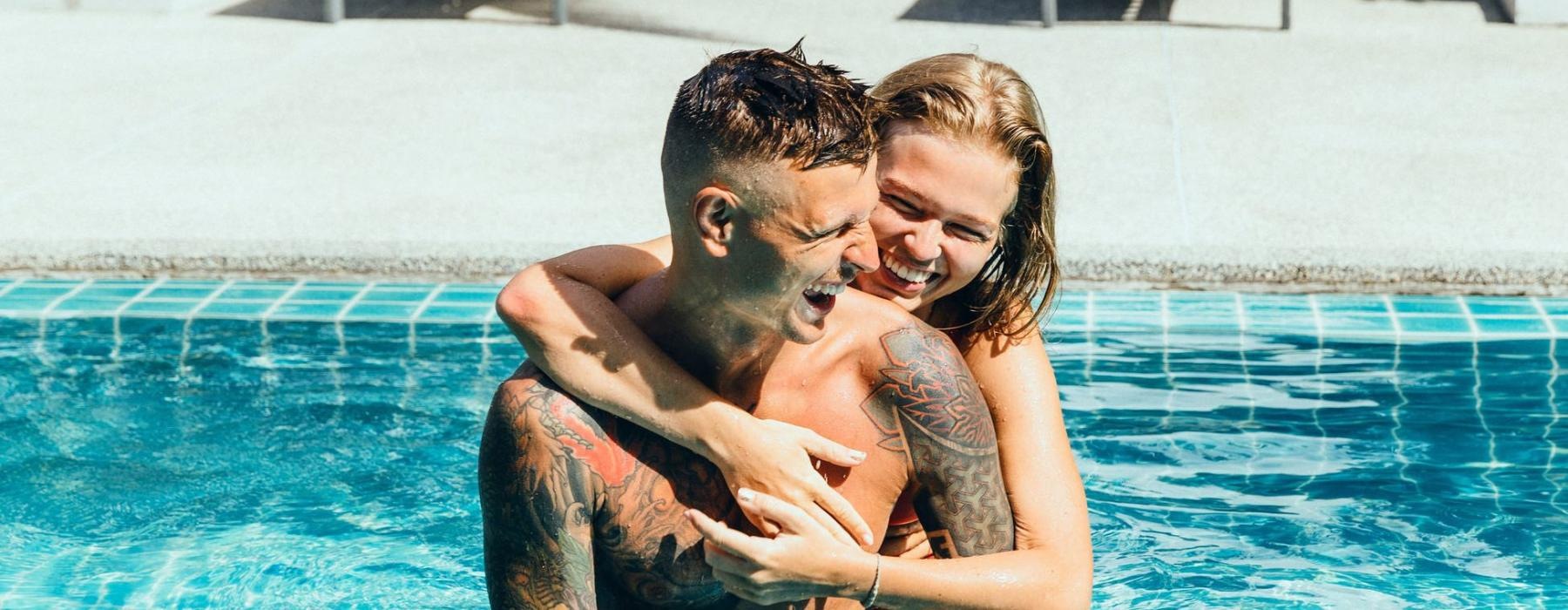 a man and woman hugging in a pool